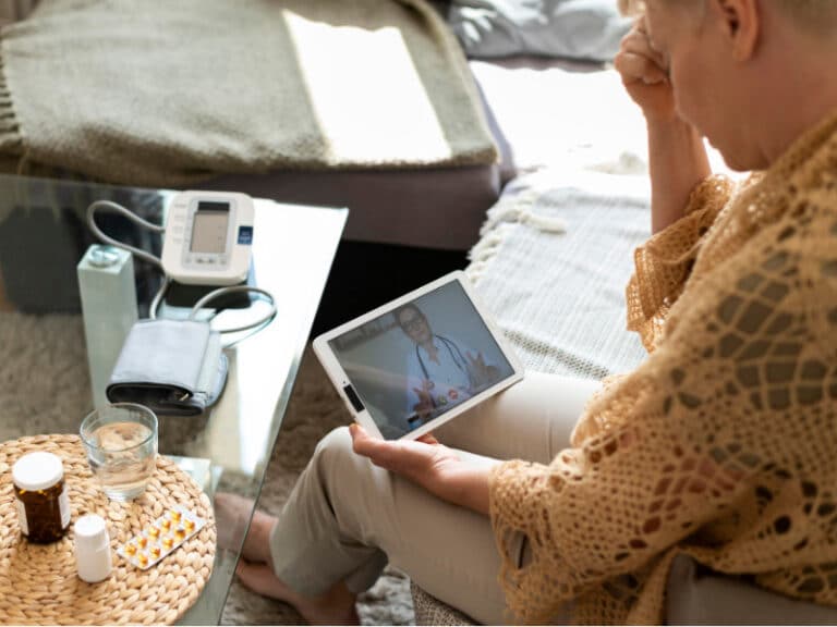 Oude vrouw praat met arts via tablet