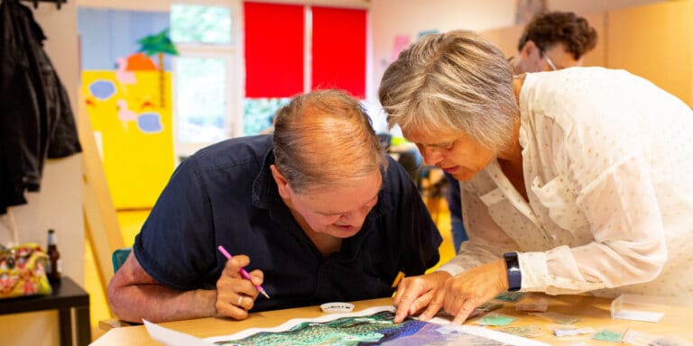 Bewoner en therapeut kijken samen naar een tekening