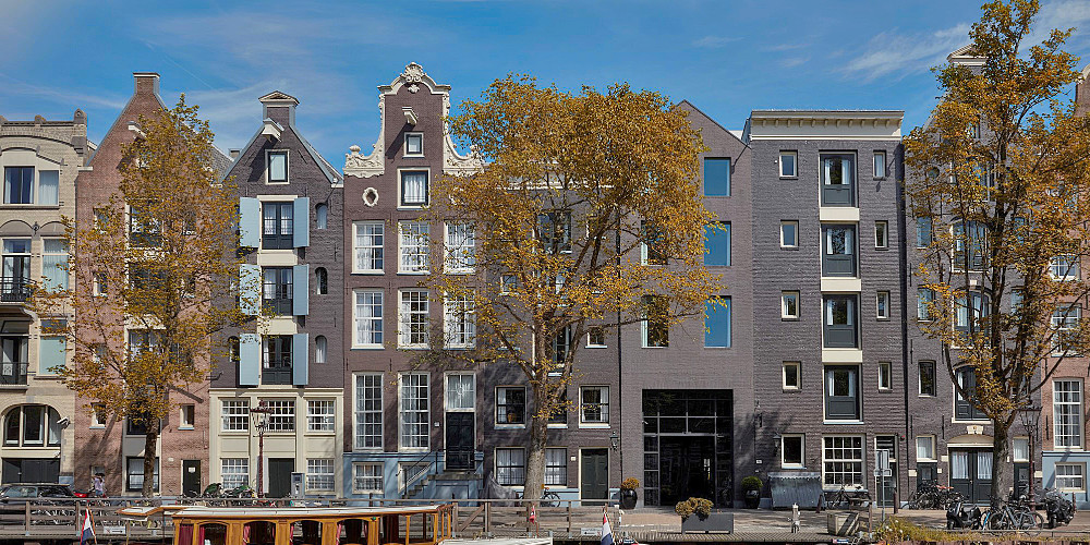 Rij oude grachtenpanden in Amsterdam aan het water